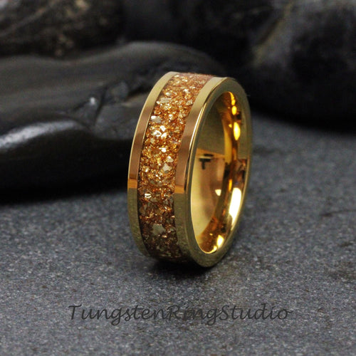 May include: A gold tungsten carbide ring with a band of sparkly gold glitter. The ring is a classic style and is perfect for a wedding band or an everyday ring.