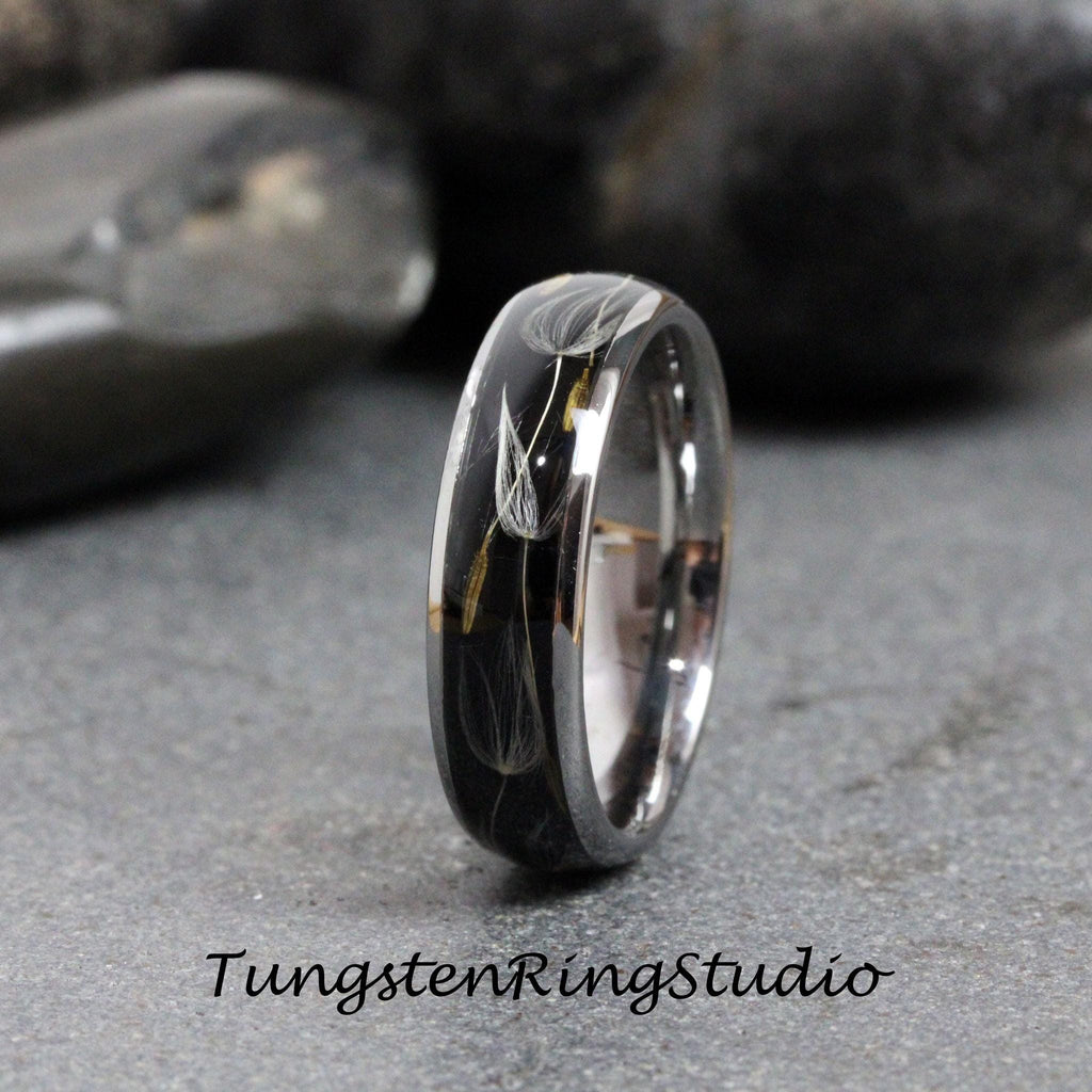 May include: A black tungsten ring with a silver band and a clear resin inlay featuring a dandelion design.