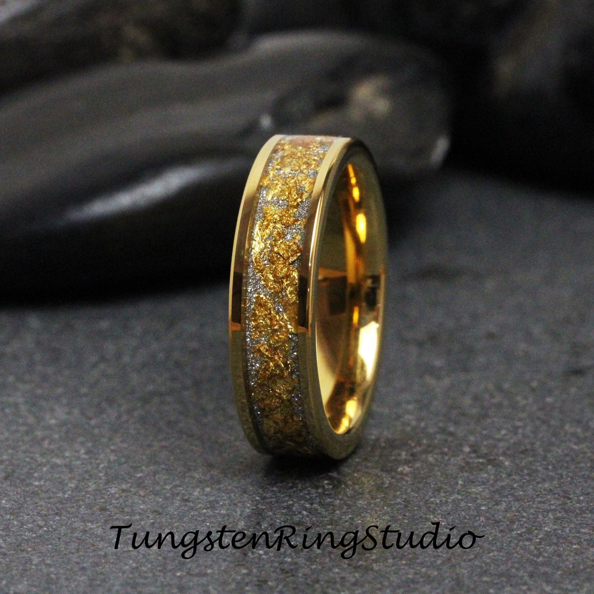 May include: A gold tungsten carbide ring with a silver and gold inlay. The ring has a polished finish and a comfortable fit.