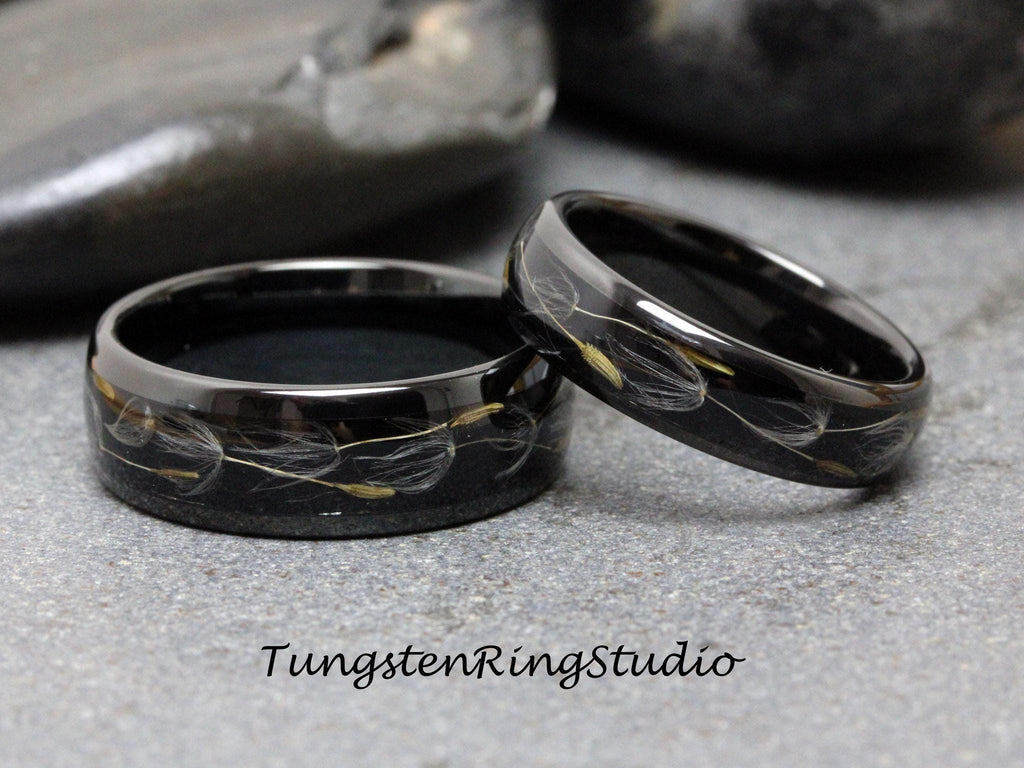 May include: Two black tungsten carbide rings with dandelion seeds embedded in the black resin. The rings are polished and have a high shine.