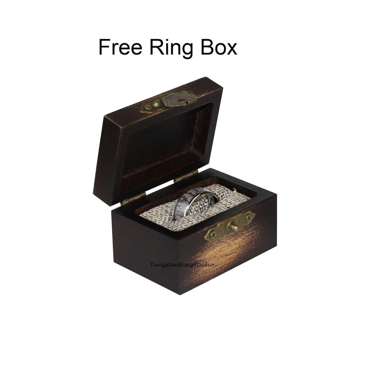 May include: A dark brown wooden ring box with a hinged lid and a brass latch. The box is open and a silver ring is inside on a piece of beige fabric.