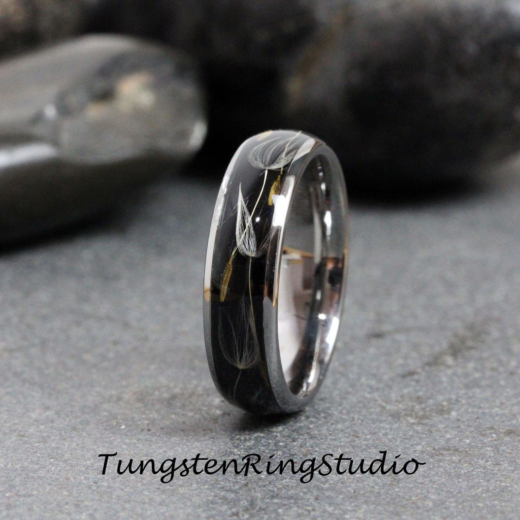 May include: A black tungsten ring with a silver band and a clear resin inlay featuring a dandelion design.