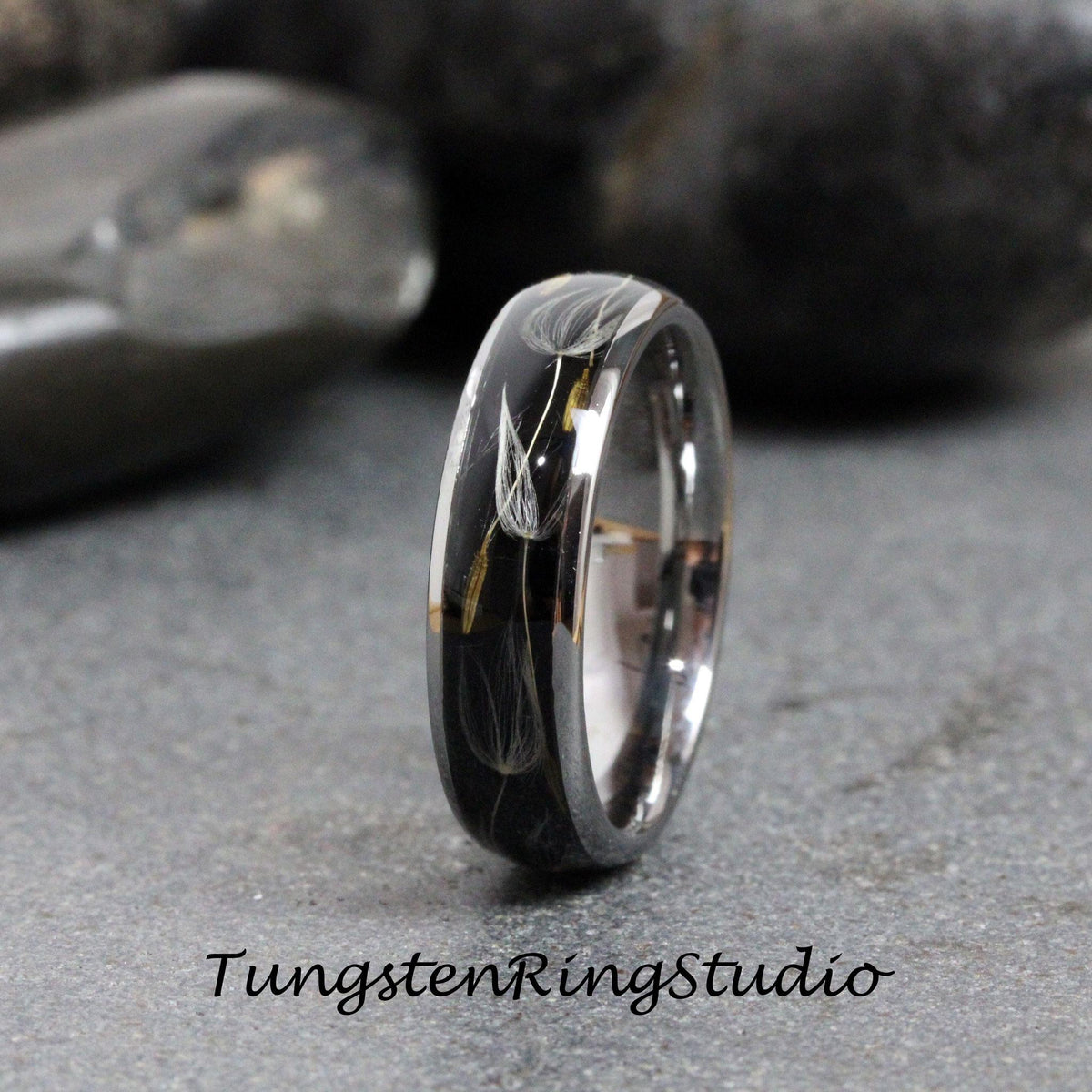 May include: A black tungsten ring with a silver band and a clear resin inlay featuring a dandelion design.