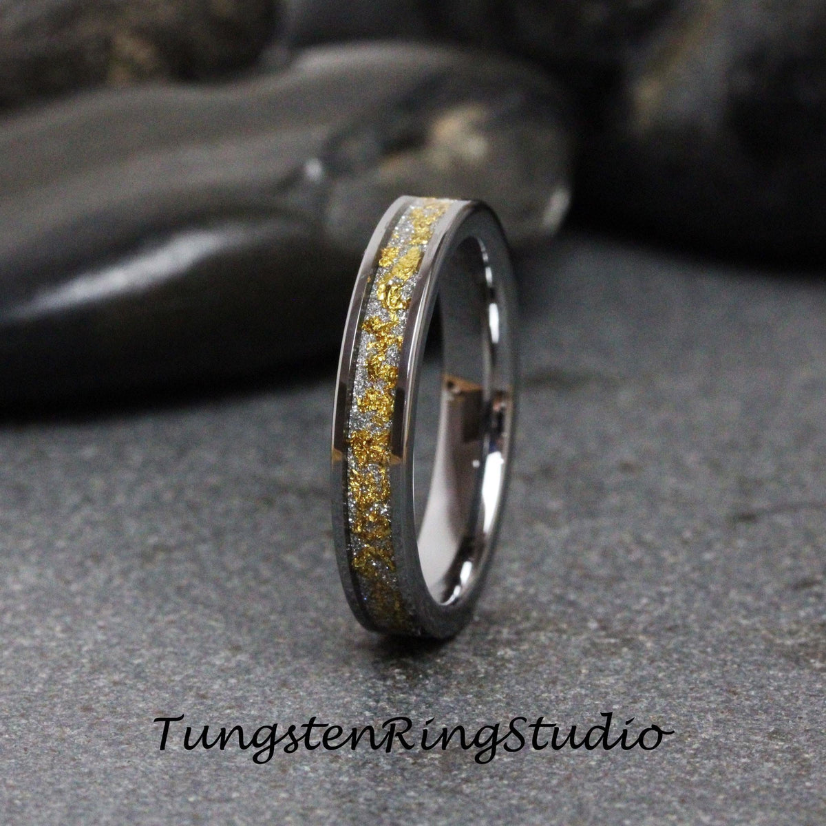 May include: A silver tungsten ring with a thin band of gold flecks.