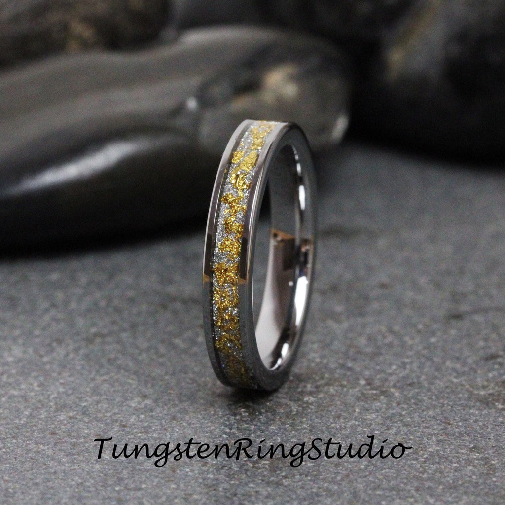 May include: A silver tungsten ring with a thin band of gold flecks.