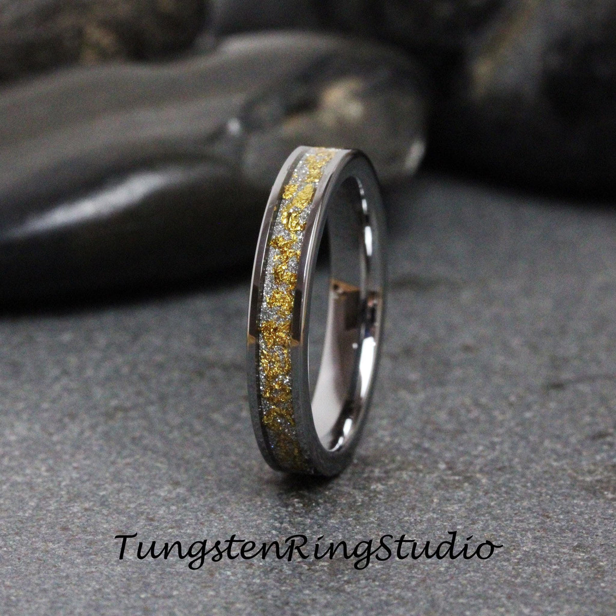 May include: A silver tungsten ring with a thin band of gold flecks.