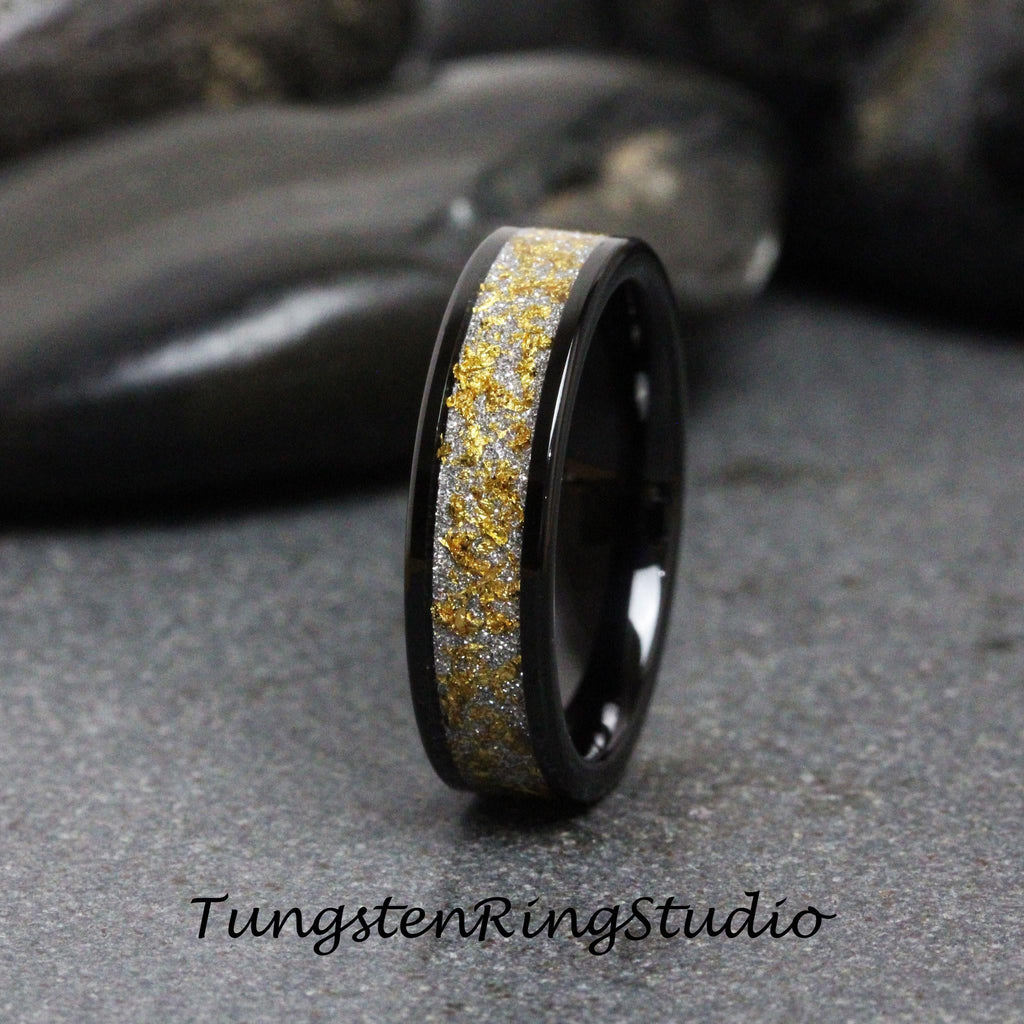 May include: A black tungsten carbide ring with a gold and silver inlay. The ring has a polished finish and a comfortable fit.