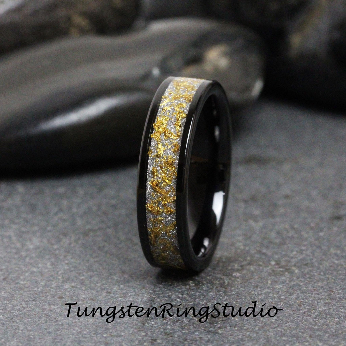 May include: A black tungsten carbide ring with a gold and silver inlay. The ring has a polished finish and a comfortable fit.