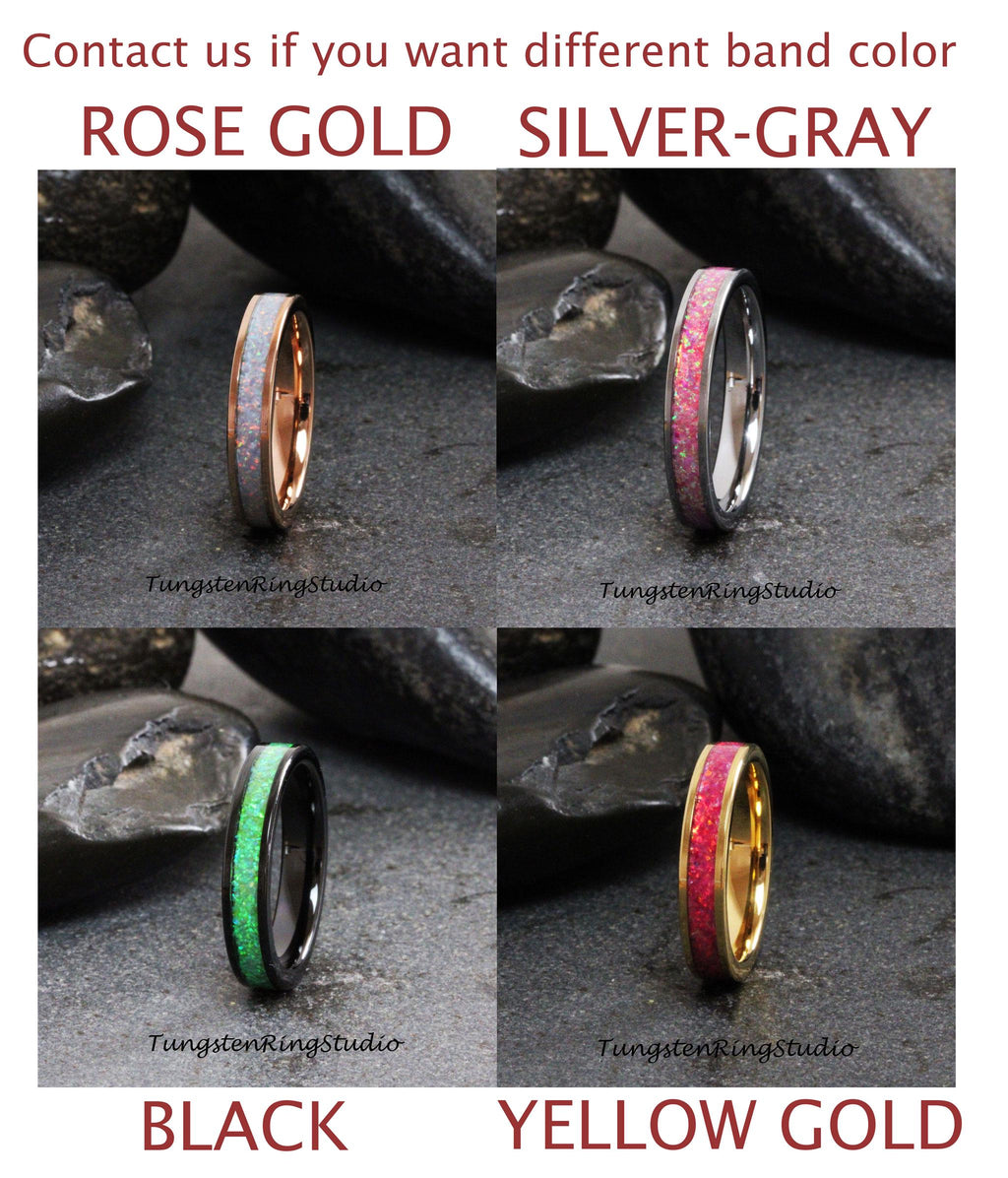 May include: Four tungsten carbide rings with different band colors: rose gold, silver-gray, black, and yellow gold. Each ring has a thin band of opal inlay.