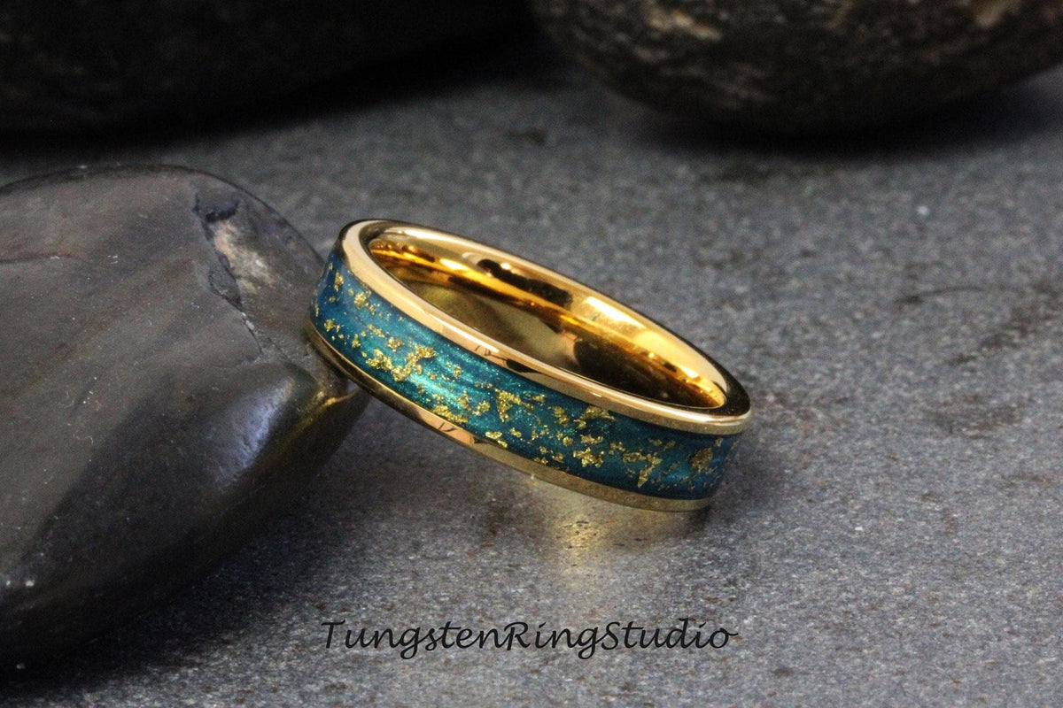 May include: A gold tungsten carbide ring with a blue and gold inlay. The ring has a brushed finish and a beveled edge.