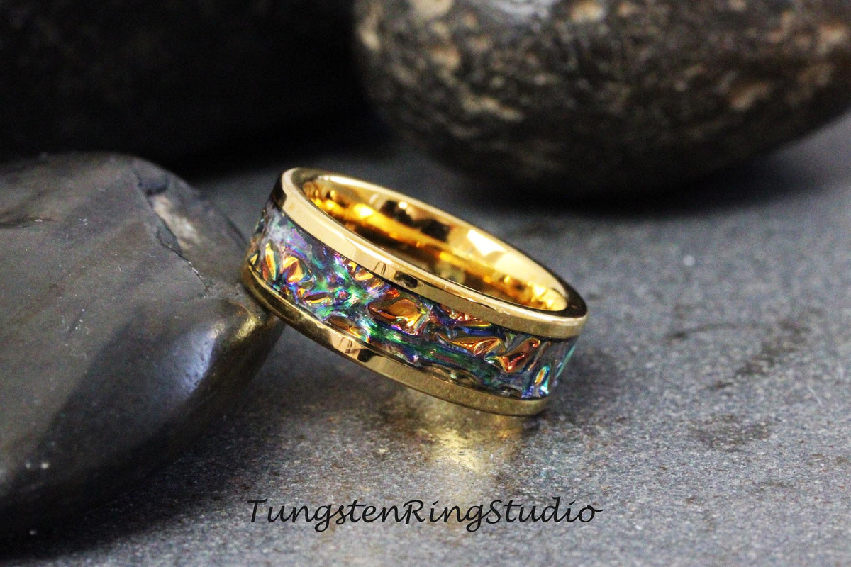 May include: A gold tungsten carbide ring with a colorful iridescent inlay. The ring is a popular choice for wedding bands and other special occasions.