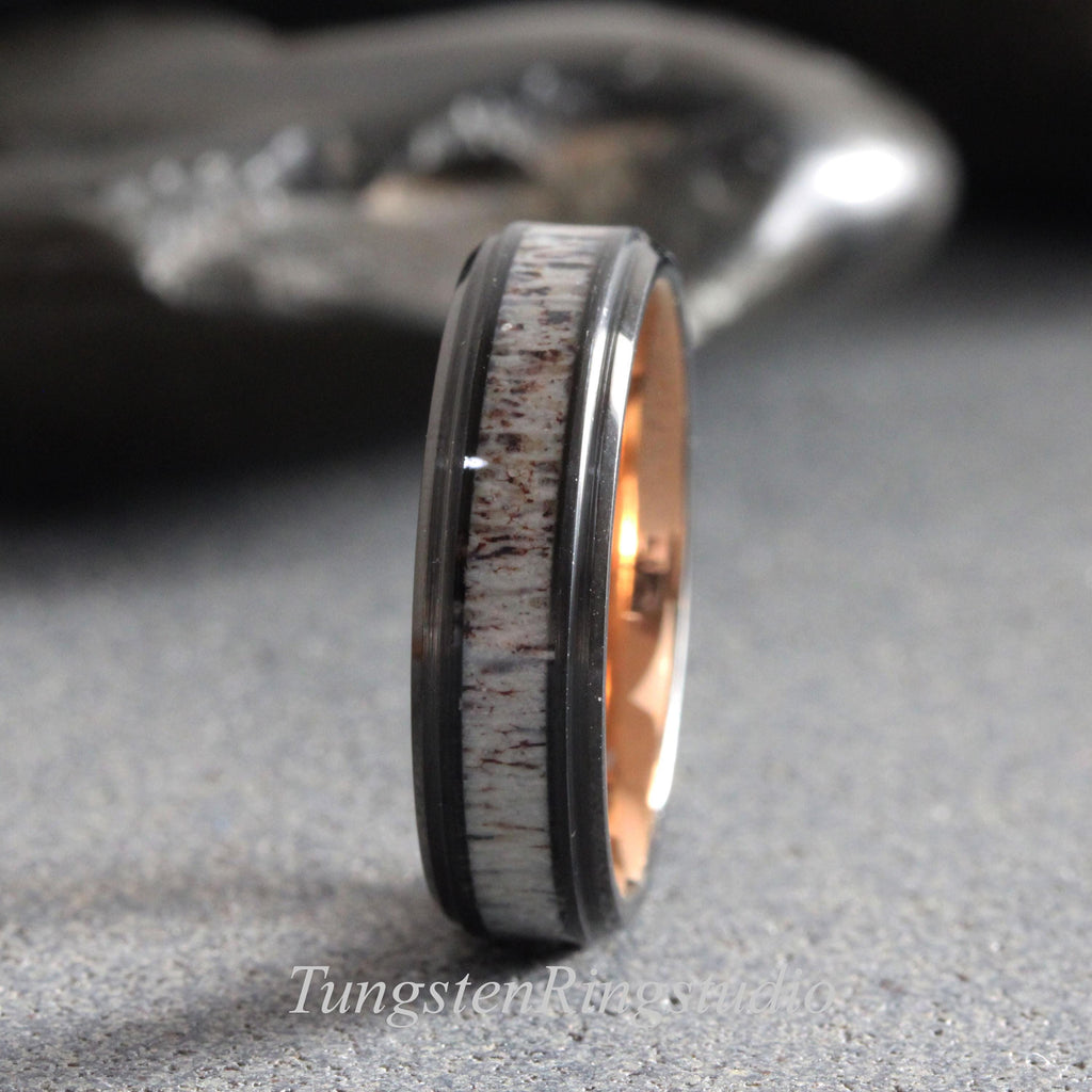 May include: A ring featuring a black tungsten band with a central inlay of textured brown and white deer antler. The interior of the band is finished in a polished rose gold tone. The text TungstenRingStudio is visible at the bottom of the image.