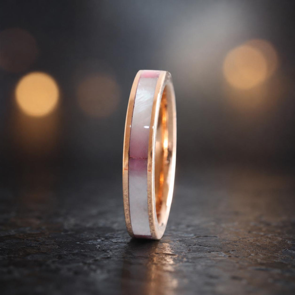 May include: A rose gold ring featuring a central inlay of iridescent white and soft pink shell material. The band has a polished metallic finish on the edges, framing the smooth, flat inlay that runs along the circumference of the circular ring.