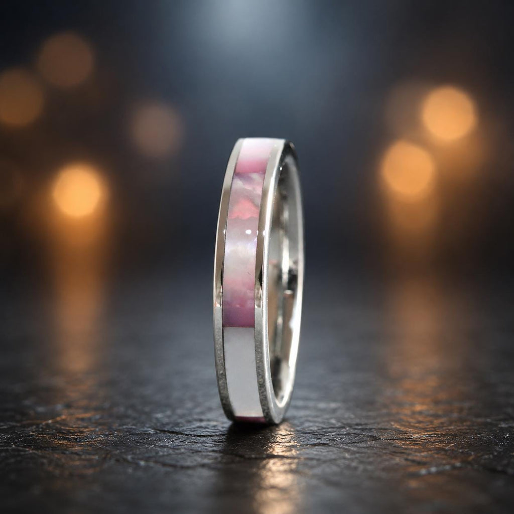 May include: A silver-toned ring featuring a central inlay band. The inlay consists of alternating rectangular segments of iridescent pink shell and solid white material, set flush within the polished metal band of the ring.