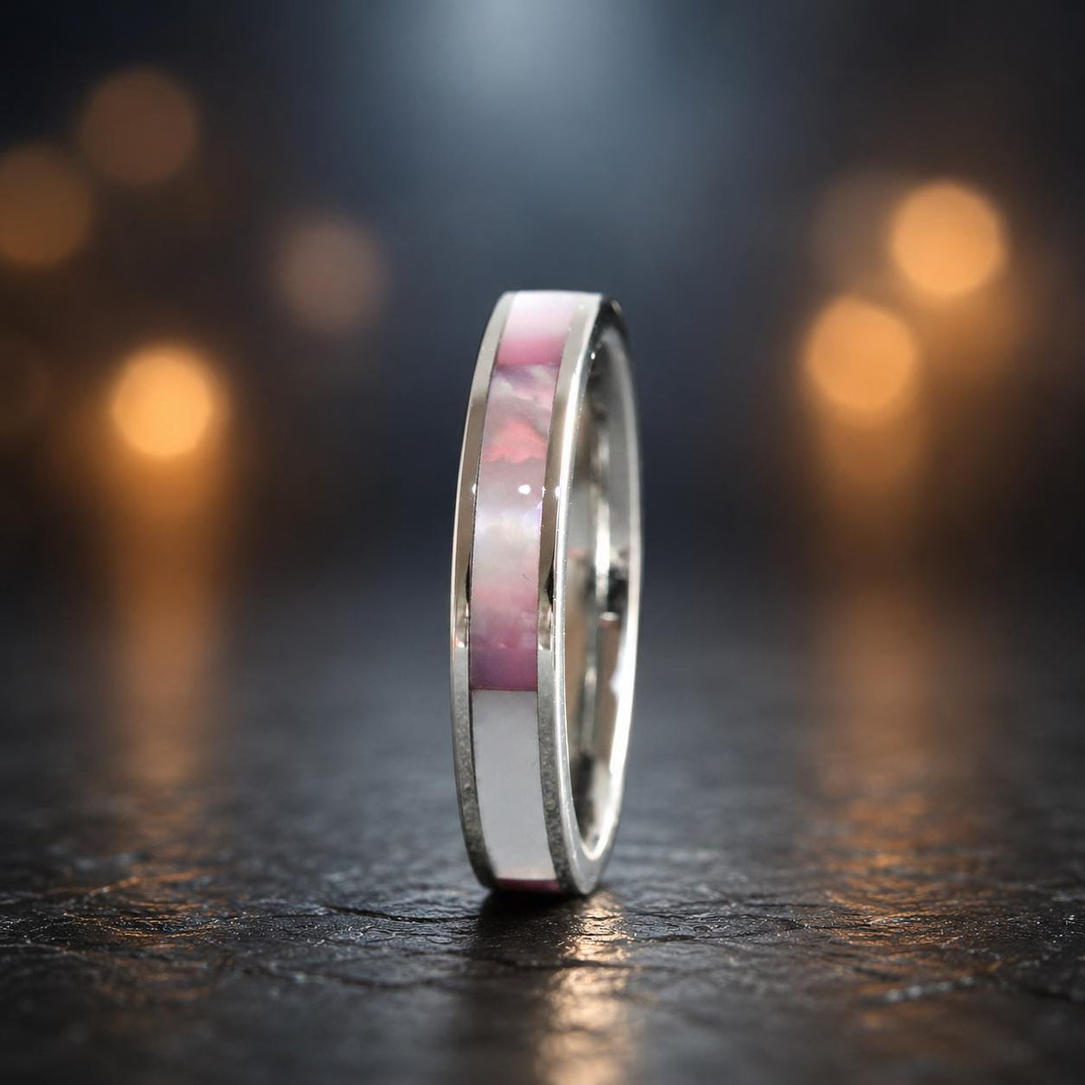 May include: A silver-toned ring featuring a central inlay band. The inlay consists of alternating rectangular segments of iridescent pink shell and solid white material, set flush within the polished metal band of the ring.